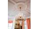 Ornate chandelier highlighting the ceiling details, complemented by natural light and elegant drapes at 5 Logan St, Charleston, SC 29401
