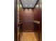An interior view of a wood paneled residential elevator showcasing its functionality and elegant design at 5 Logan St, Charleston, SC 29401