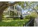 Exterior view of a yellow two-story home with black shutters and a well-manicured front yard at 5 Logan St, Charleston, SC 29401