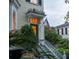 Charming home exterior features a stained glass door, an American flag, and a staircase framed by greenery at 5 Logan St, Charleston, SC 29401