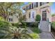 Exterior elevation of a charming home with black shutters, a bay window, and a manicured front yard at 5 Logan St, Charleston, SC 29401