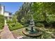 Beautifully landscaped garden with a tiered fountain and manicured boxwoods at 5 Logan St, Charleston, SC 29401