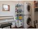 Functional laundry room with washer, dryer, shelving for storage, and clothing press at 5 Logan St, Charleston, SC 29401