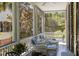 Inviting screened porch with wicker seating, ceiling fan, and views of lush greenery at 5 Logan St, Charleston, SC 29401