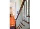 Staircase featuring wooden treads, white spindles, and a glimpse into adjoining rooms, showcasing the home's layout at 5 Logan St, Charleston, SC 29401