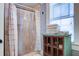 Tiled bathroom featuring a shower with decorative curtain and a vintage storage cabinet at 5126 Highway 174, Hollywood, SC 29449