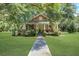 Charming home featuring a well-manicured lawn, inviting porch, and beautiful mature trees at 5126 Highway 174, Hollywood, SC 29449