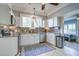 Modern kitchen with white cabinets, mosaic backsplash, stainless steel appliances, and a view to the sunroom at 5126 Highway 174, Hollywood, SC 29449