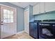Functional laundry room with modern washer and dryer, storage cabinets, and convenient access to the outside at 5126 Highway 174, Hollywood, SC 29449