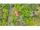 Aerial view of red-roofed house surrounded by lush trees and greenery with road access at 516 Hope Plantation Ln, Jacksonboro, SC 29452