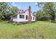 Side view of a quaint home with a red brick chimney, set on a green lawn with mature trees at 516 Hope Plantation Ln, Jacksonboro, SC 29452