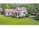 Aerial view of a delightful home with a red roof, charming porch, and meticulously landscaped yard at 516 Hope Plantation Ln, Jacksonboro, SC 29452