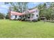 Lovely farmhouse with red metal roof, expansive lawn, and inviting front porch at 516 Hope Plantation Ln, Jacksonboro, SC 29452