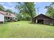 Scenic view of the home and storage shed on a lush, grassy lot with mature trees at 516 Hope Plantation Ln, Jacksonboro, SC 29452