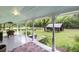 Inviting front porch with decorative ceiling, wicker furniture, and a view of the landscaped yard and outbuilding at 516 Hope Plantation Ln, Jacksonboro, SC 29452