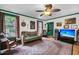 Inviting living room features a ceiling fan, large windows, hardwood floors, and vintage decor at 516 Hope Plantation Ln, Jacksonboro, SC 29452