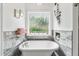 Stylish bathroom features a freestanding tub with elegant fixtures and a decorative window at 555 Pointe Of Oaks Rd, Summerville, SC 29485