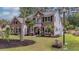 Charming two-story home with brick and siding exterior, complemented by lush landscaping and mature trees at 555 Pointe Of Oaks Rd, Summerville, SC 29485
