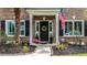 Inviting entryway featuring a black front door with wreath, flanked by plants and American flag at 555 Pointe Of Oaks Rd, Summerville, SC 29485