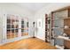 Hallway with French doors leading to the dining room, complemented by hardwood floors and a stylish bookshelf at 555 Pointe Of Oaks Rd, Summerville, SC 29485