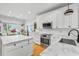 Bright kitchen featuring white cabinets, marble countertops, stainless steel appliances, and hardwood floors at 555 Pointe Of Oaks Rd, Summerville, SC 29485