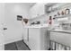 Laundry room with white washer and dryer and stainless steel sink and black floors at 555 Pointe Of Oaks Rd, Summerville, SC 29485