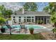 An inviting backyard pool area is enhanced with comfortable lounge chairs and lush, mature landscaping at 555 Pointe Of Oaks Rd, Summerville, SC 29485