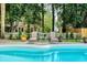 Backyard pool view surrounded by manicured landscaping, with lounge chairs perfect for relaxation by the water at 555 Pointe Of Oaks Rd, Summerville, SC 29485