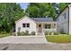 Charming white home features a welcoming front porch, well-manicured landscaping, and a large driveway at 5814 Knight St, Hanahan, SC 29410