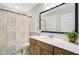 Bright bathroom featuring wood vanity, white countertop, framed mirror, and decorative shower curtain at 596 Dunswell Dr, Summerville, SC 29486