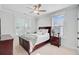 Cozy bedroom with a wooden bed frame, ceiling fan, and natural light from two windows at 596 Dunswell Dr, Summerville, SC 29486