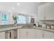 Stylish kitchen with granite countertops, white cabinetry, and a view into the living room at 596 Dunswell Dr, Summerville, SC 29486