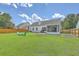 Spacious backyard featuring a well-maintained lawn, privacy fence, screened-in patio, and fire pit area at 6179 Fieldstone Cir, Charleston, SC 29414