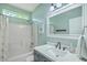 This bathroom has a shower/tub combo, white cabinets, and bright lighting at 6179 Fieldstone Cir, Charleston, SC 29414