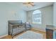 Cozy bedroom featuring hardwood floors, neutral walls, and a bright arched window at 6179 Fieldstone Cir, Charleston, SC 29414