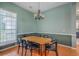 Cozy dining room with warm wood floors, wainscoting, and an elegant chandelier over a wooden table at 6179 Fieldstone Cir, Charleston, SC 29414