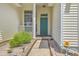 Close-up of the front entrance, featuring a teal door, decorative stonework, and attractive landscaping at 6179 Fieldstone Cir, Charleston, SC 29414