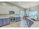 Bright kitchen with stainless appliances, two-tone cabinets, stone countertops, and dining area at 6179 Fieldstone Cir, Charleston, SC 29414