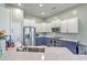 Bright kitchen features stainless appliances, white and blue cabinets and stone countertop at 6179 Fieldstone Cir, Charleston, SC 29414