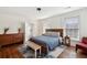 Bedroom with hardwood floors, wooden bed frame, bench, and lots of natural light from windows at 66 Beaufain St, Charleston, SC 29401