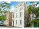 Three-story home showcases classic architectural style, accented by green foliage and an American flag at 66 Beaufain St, Charleston, SC 29401