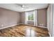 A spacious bedroom features wood-look floors, ceiling fan and a large window with natural light at 680 Buckhall Ct, Mount Pleasant, SC 29464