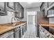 Galley kitchen featuring stainless steel appliances, butcher block countertops, and white tiled floors at 680 Buckhall Ct, Mount Pleasant, SC 29464