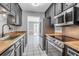 Galley kitchen featuring stainless steel appliances, butcher block countertops, and white tiled floors at 680 Buckhall Ct, Mount Pleasant, SC 29464