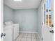 Bright laundry room with washer, dryer, white tile floors, and a backyard view at 680 Buckhall Ct, Mount Pleasant, SC 29464