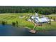 Aerial view of community amenities, including a lake, clubhouse, pool, playground, and pier at 682 Pontoon Rd, Huger, SC 29450
