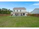 Expansive backyard with lush lawn and covered patio, perfect for outdoor entertaining at 682 Pontoon Rd, Huger, SC 29450