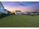 A large backyard with raised garden beds, manicured lawns, and a sunset view at 682 Pontoon Rd, Huger, SC 29450