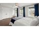 Bright bedroom featuring two windows with dark blue curtains, a ceiling fan, and wood floors at 682 Pontoon Rd, Huger, SC 29450