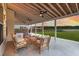 Covered patio with comfortable seating overlooking a serene sunset view at 682 Pontoon Rd, Huger, SC 29450